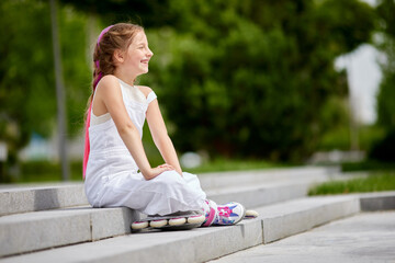 cute little girl on roller skates at park.