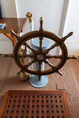 A wooden ships wheel in the wheelhouse or Bridge of a ship © Seadog81
