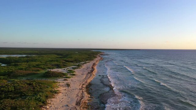 Aerial: Scenic View Of Waves Splashing On Beach Coastline, Drone Flying Over Structures Over Landscape - Cozumel, Mexico