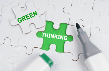White puzzles lie on a green background, in place of an open puzzle it is written - Green Thinking