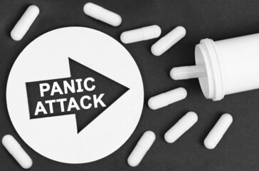 Pills on a black background. They are indicated by a circle with an arrow, inside which it is written -PANIC ATTACK