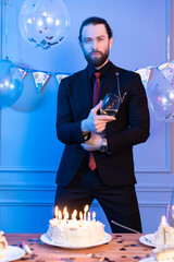 man with a beautiful beard poses for the camera during a photo shoot organized for him in the studio on his birthday
