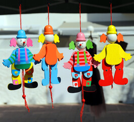 Articulated wooden toys of colored clowns for sale at a craft flea market. Wooden handmade jester...