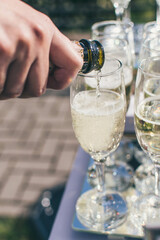 Glasses of popping champagne. Pouring champagne into champagne glasses close up