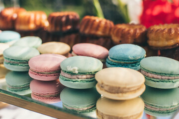 Close-up of pastel color macaroons or macarons  on a mirror surface. Birthday dessert. Sweets for the candy bar. Festive sweets. French confectionery.