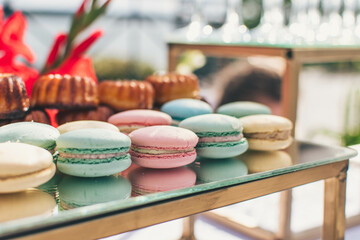 Close-up of pastel color macaroons or macarons  on a mirror surface. Birthday dessert. Sweets for the candy bar. Festive sweets. French confectionery.