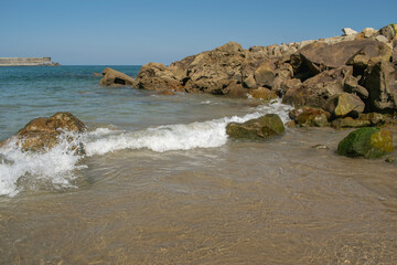 Waves crashing on a beach with rocks