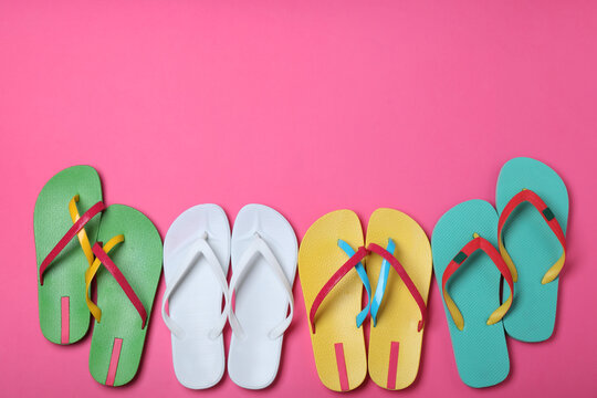 Many different flip flops on pink background, flat lay. Space for text