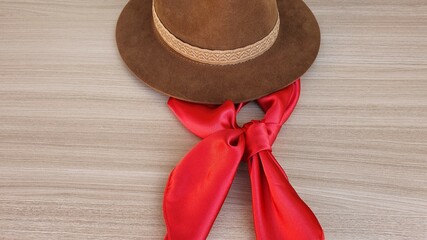 Hat and red scarf on the table. Gaucho tradition accessories. Rio Grande do Sul, Brasil.