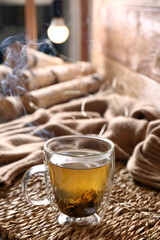 Wicker mat with freshly brewed tea in room. Cozy home atmosphere