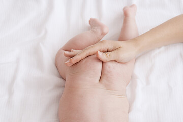 mom stroking baby's buttocks