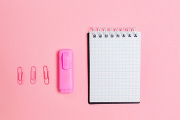 Back to school. Notepad, marker and clips on pink background. Flat lay. Mock up. Copy space. Concept of education