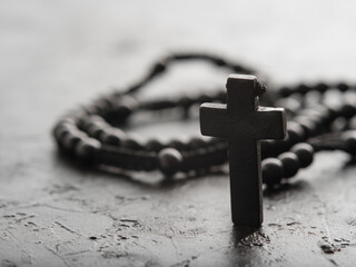 Rosary and crucifix on a gray background. Minimalism. Close-up. The concept is religion,...