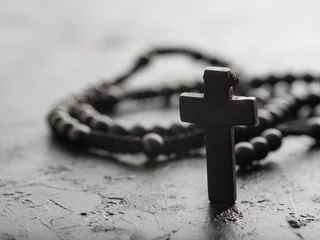 Foto op Plexiglas Rosary and crucifix on a gray background. Minimalism. Close-up. The concept is religion, Christianity, Catholicism, faith, spirituality, prayer, meditation. © Anton