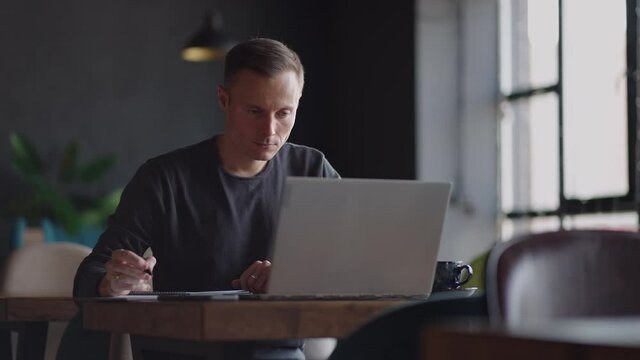 Hispanic latin man college student using laptop computer watching distance online learning seminar class, remote university webinar or having virtual classroom meeting in university creative space.