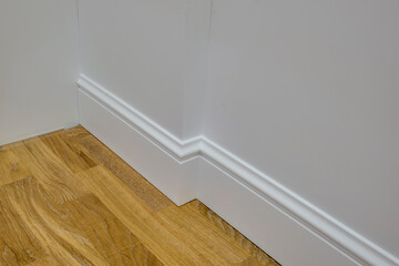 Detail of corner flooring with intricate crown molding and plinth.