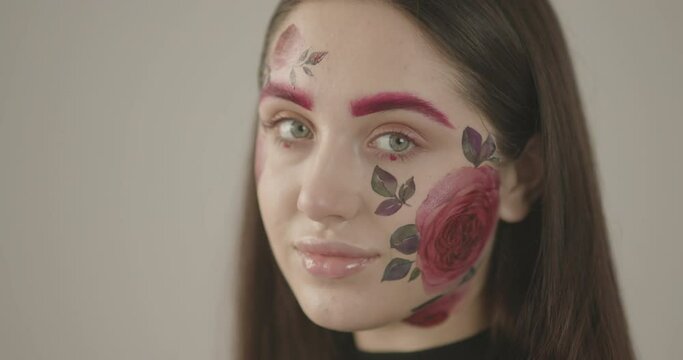 portrait of a beautiful girl with bright green eyes that clearly emphasize the pink flowers on her face