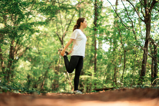 Young woman waves away mosquitoes, scratching herself from insect bites. Summer forest in the background. Real time