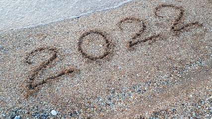 the year 2022 is written on the sand on the beach. the new year is coming soon. the next year of the tiger according