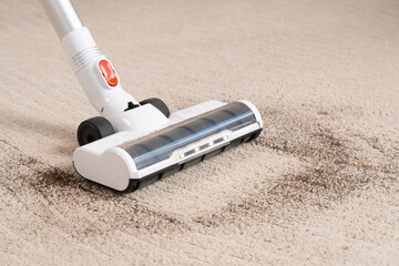 Close-up of vacuum cleaner brush cleaning home carpet. dirt on carpet.