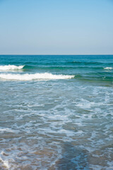 Sea or ocean tropical landscape view. Sea waves under the sun. Summer vacation and travel concept. Water wave surface. Sand beach. 