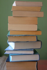 Stack of books with blue and green covers. Selective focus.