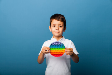 The boy holds clapping toys in his hands. Push game. Happy boy with pop it.