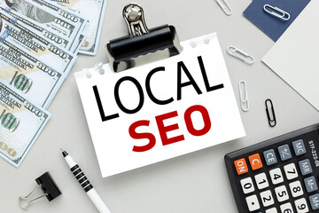 Local SEO. text on white paper on gray background near money.