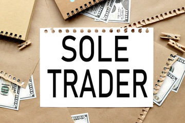 SOLE TRADER, text on white notepad paper on craft background