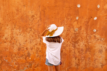 Menina de chapéu com fita dourada em fundo colorido