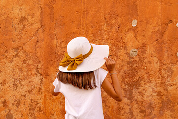 Menina de chapéu com fita dourada em fundo colorido