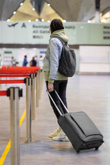 Fototapeta premium European woman at the airport waiting to board her flight, flight and boarding delays, restrictions on international airline flights, Caucasian woman bored at the airport in the waiting area