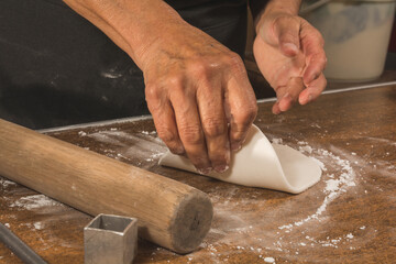 Worker preparing typical Mexican sweets made from Alfeñique, used during the Dia de Muertos festival to put on altars. The person's hands and the molds and the dough are distinguished.