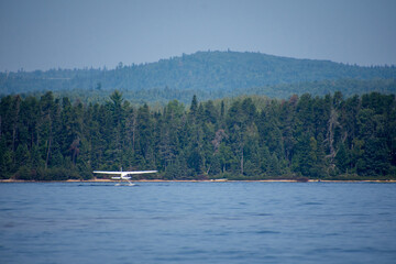Fototapeta na wymiar Seaplane taking off on a wild lake in Quebec, Canada