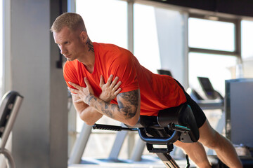 attractive strong handsome athlete man pumping up muscles in gym. muscle guy workout. exercises for press. active healthy lifestyle. bodybuilding, sports, fitness.