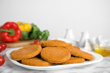 Fototapeta na wymiar Delicious fried breaded cutlets on white marble table