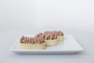 Tartlet with chocolate mousse on a white plate for catering, space for design