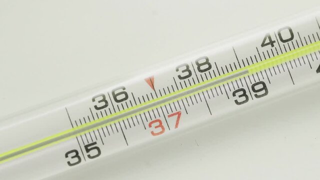 A close-up of a glass mercury thermometer shows a low temperature
