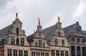 Fototapeta na wymiar Antwerpen, Belgium - August 1, 2021: Grote Markt historic medieval houses. Row of 4 gables, the Luipaert, unknown, the Meersman, and the Beer against a gray sky. Golden statues and frescos.