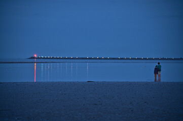 Beautiful evening view couple standing in water and waiting for blue sturgeon Moon rising over...