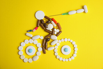Sportsman, bike and syringe made of pills on yellow background, flat lay. Using doping in cycling sport concept