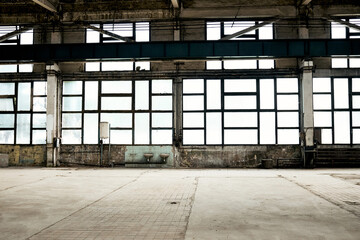 Vintage abandoned industrial hall interior with lots of windows, dark shadows and light