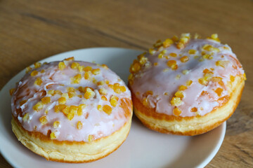 There are delicious doughnuts on the plate. Desserts for coffee or tea.