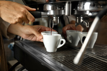 Fototapeta na wymiar Barista making espresso using professional coffee machine, closeup