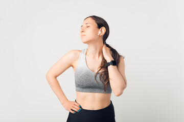 Fototapeta premium Young lady wearing sportswear is taking a break because of her neck aches.