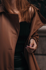 Stylish brown autumn fashionable coat on a female figure. Street fashion details