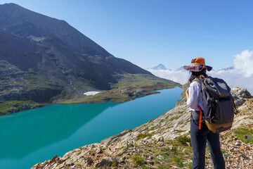 Woman hiking a trail around a Lake. Lac Blanc, Alpes d'Huez. French Alps