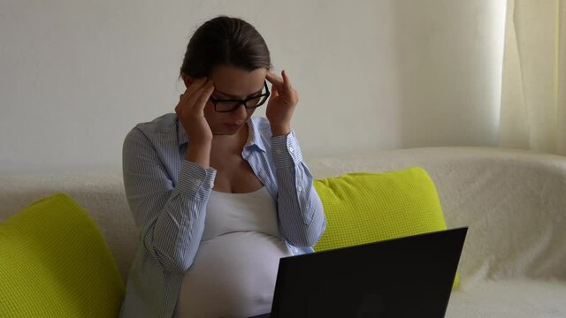 Tired stressful Stressed upset Pregnant business Woman With Laptop rest on Sofa. Depressed Ledy In Pregnancy Work Remotely Using Smartphone Internet Online Technology At Home. Maternity leave Concept
