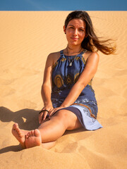 Young Latin Woman Sitting on the Sand of the Beach, Enjoying the Sunset in Dunes of Taroa, La...