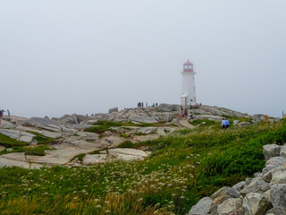 Fototapeta na wymiar Foggy day at the lighthouse at Peggy's Cove in Nova Scotia, Canada.